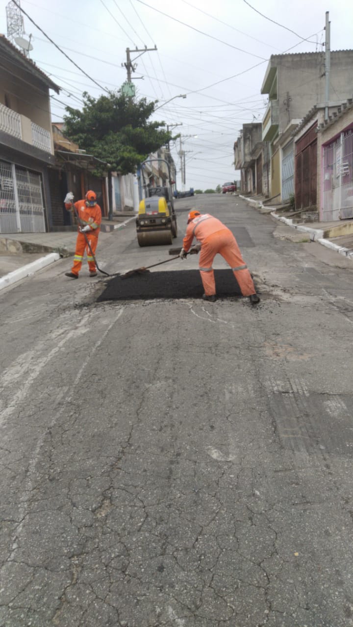 local do buraco tapado é notável, com mancha retangular preta, no meio da pista